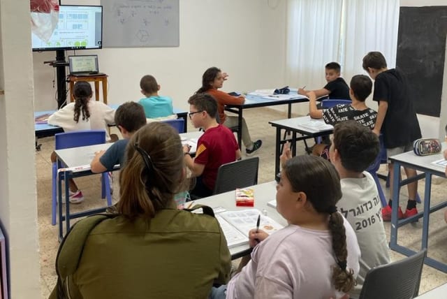 An IDF soldier accompanies students in class to help bolster their learning (photo credit: IDF SPOKESPERSON'S UNIT)