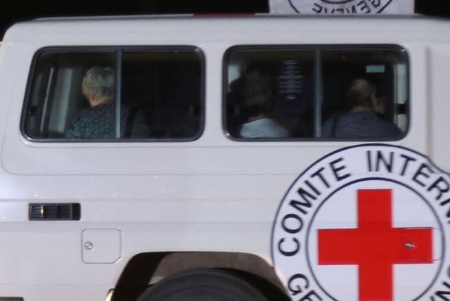 A red cross vehicle, which is part of a convoy arrives at the Rafah border crossing, amid a hostages-prisoners swap deal between Hamas and Israel, in the southern Gaza Strip November 24, 2023 (photo credit: REUTERS/IBRAHEEM ABU MUSTAFA)
