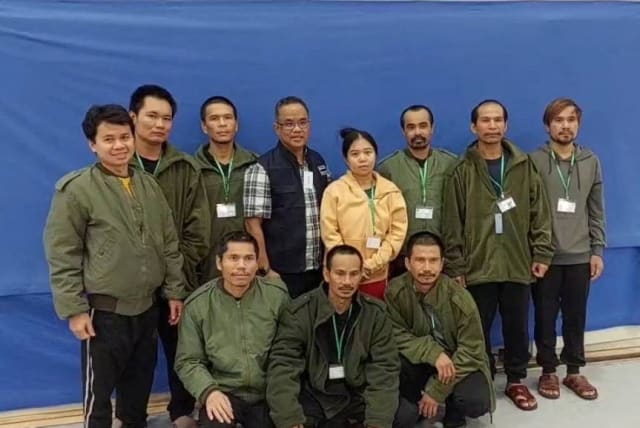  Thai workers taken hostage by Hamas and later released as part of a deal between Israel and Palestinian terrorist group Hamas, pose with a member of Thai mission after a medical checkup, in Tel Aviv, Israel, in this handout image released on November 25, 2023. (photo credit: Ministry Of Foreign Affairs Thailand/Handout via REUTERS)