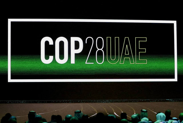  'Cop28 UAE' logo is displayed on the screen during the opening ceremony of Abu Dhabi Sustainability Week (ADSW) under the theme of 'United on Climate Action Toward COP28', in Abu Dhabi (photo credit: REUTERS)