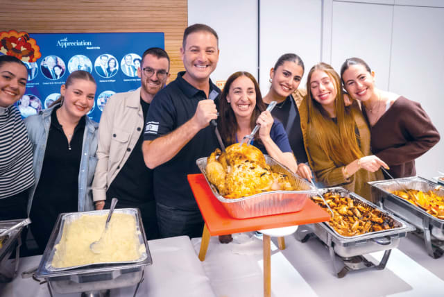  CARVING THE turkey: StandWithUs executive director (C) Michael Dickson with Michael Levin Base co-director Lizzie Noach, and volunteers. (photo credit: Chaimhphotography)
