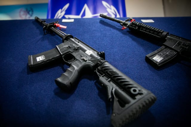  Illegal weapons are displayed during a ceremony in Ma'ale Adumim, after a large police operation against illegal gun dealers, September 7, 2022.  (photo credit: OREN BEN HAKOON/FLASH90)