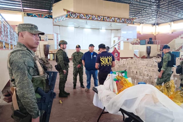 Lanao Del Sur Governor Mamintal Adiong Jr. stands among law enforcement officers as they investigate the scene of an explosion that occurred during a Catholic Mass in a gymnasium at Mindanao State University in Marawi, Philippines, December 3, 2023. (photo credit: Lanao Del Sur Provincial Government/Handout via REUTERS)