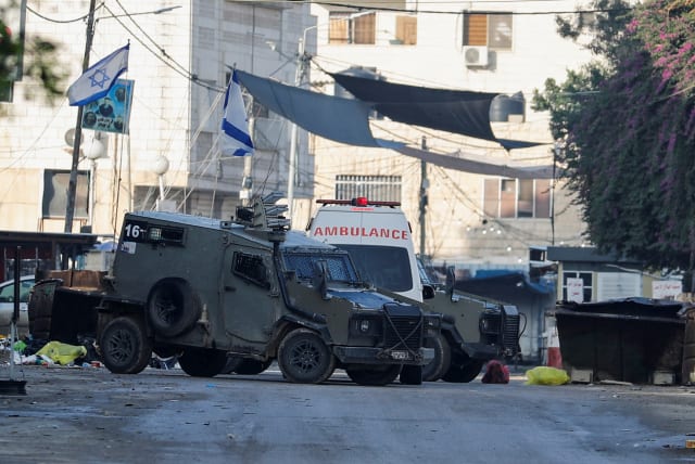 Israeli military vehicles seen during a raid in Jenin, amid the ongoing conflict between Israel and the Palestinian terrorist group Hamas, in the West Bank, December 12, 2023. (photo credit: RANEEN SAWAFTA/REUTERS)
