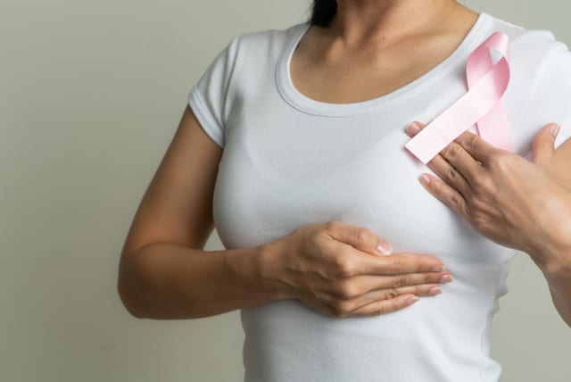  A woman is seen holding a pink ribbon, symbolizing breast cancer awareness. (photo credit: INGIMAGE)
