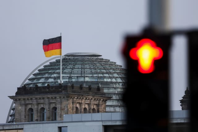 The red traffic light is seen near the Reichstag building, the seat of Germany's lower house of parliament Bundestag, in Berlin, Germany November 24, 2023. (photo credit: REUTERS/Liesa Johannssen)