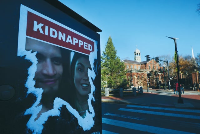  A POSTER of people taken hostage during the October 7 Hamas attack on Israel is torn, outside the gates of Harvard University.  (photo credit: BRIAN SNYDER/REUTERS)