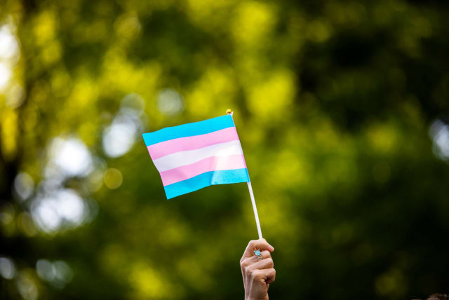  Transgender rights activist waves a transgender flag as they protest the killings of transgender women this year, at a rally in Washington Square Park in New York, U.S., May 24, 2019. (photo credit: REUTERS/Demetrius Freeman)