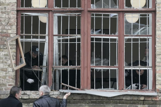 Investigators inspect an office where a grenade exploded in Kiev March 11, 2009. An unidentified attacker hurled a grenade through the window of an office linked to Kiev's main railway station, wounding seven people, Ukrainian security forces said. (photo credit: REUTERS/KONSTANTIN CHERNICHKIN)
