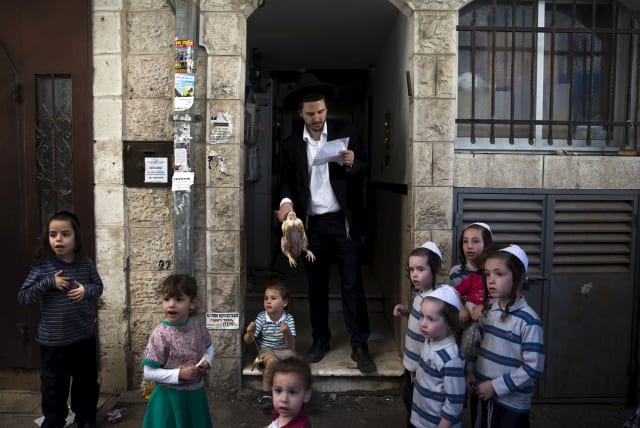  An ultra-Orthodox Jewish family performs the Kaparot ritual in Jerusalem's Mea Shearim neighbourhood, September 20, 2015 (photo credit: RONEN ZVULUN/REUTERS)