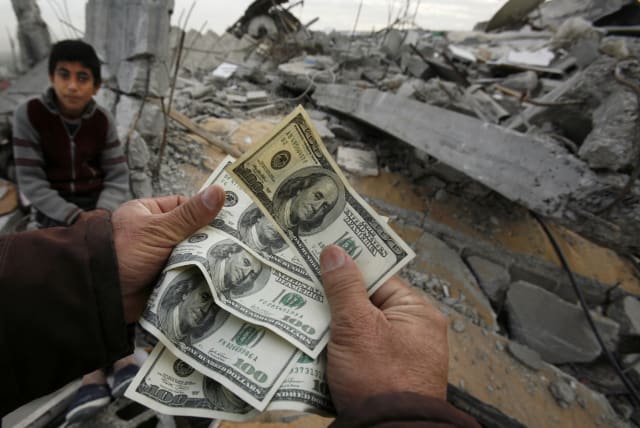  A Palestinian whose house was destroyed during Israel's offensive, shows money distributed by Hamas in Jabalya in the northern Gaza Strip January 28, 2009. (photo credit: SUHAIB SALEM/REUTERS)