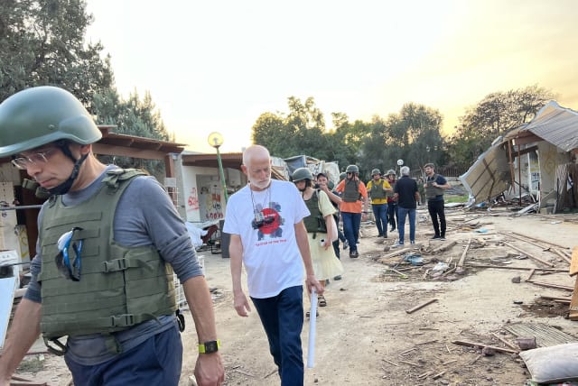  Israel Lander, in a T-shirt proclaiming “Bring Them Home Now” and “Kfar Aza is my home,” leads the delegation of European MPs around the ruins of Kibbutz Kfar Aza, near Israel's border with the Gaza Strip. (photo credit: FELICE FRIEDSON/THE MEDIA LINE)