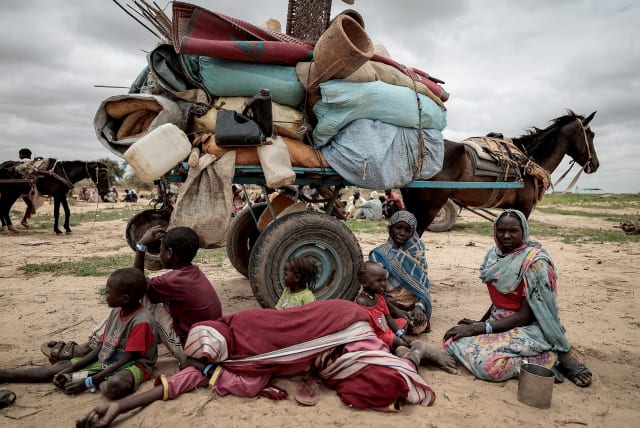  A Sudanese family who fled the conflict in Murnei in Sudan's Darfur region, sit beside their belongings while waiting to be registered by UNHCR upon crossing the border between Sudan and Chad in Adre, Chad, July 26, 2023.  (photo credit: REUTERS/ZOHRA BENSEMRA)