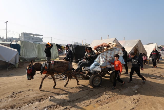  People transport belongings on an animal-drawn cart as displaced Palestinians, who fled their homes due to Israeli strikes, shelter in a tent camp in Rafah, southern Gaza Strip, January 1, 2024 (photo credit: REUTERS/IBRAHEEM ABU MUSTAFA)