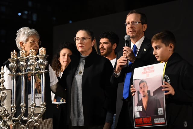  (L-R) Michal Herzog and President Isaac Herzog light Hanukkah candles with family members of people taken hostage in Gaza., at Hostage Square in Jerusalem.  (photo credit: Courtesy)