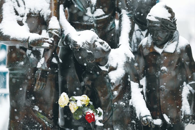  FLOWERS ARE laid at the sculpture 'Trains to Death' by Frank Meisler and Arie Ovadia at Friedrichstrasse train station in Berlin. (photo credit: TOBIAS SCHWARZ / REUTERS)