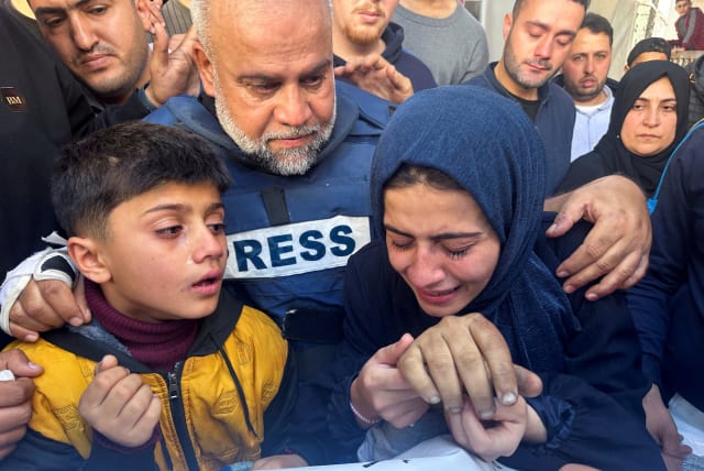  Al Jazeera journalist Wael Al-Dahdouh hugs his daughter and son as they attend the funeral of his son, Palestinian journalist Hamza Al-Dahdouh, after Hamza was killed in an Israeli strike, in Rafah in the southern Gaza Strip, January 7, 2024.  (photo credit: REUTERS/MOHAMMED SALEM)