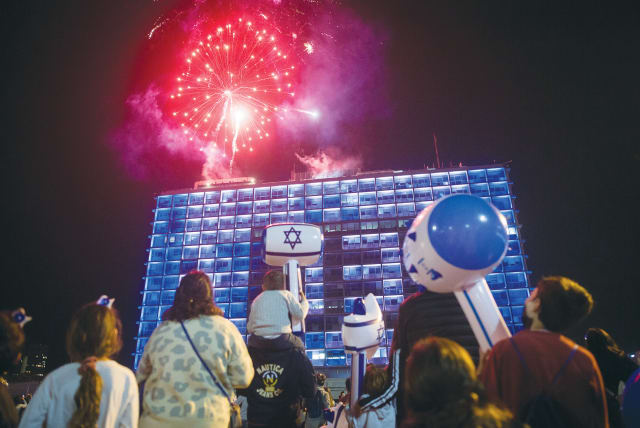  REVELERS WATCH fireworks on Independence Day, at Rabin Square in Tel Aviv. ‘When I first made aliyah, I found it so hard to understand the transition in an instant from the sadness of Remembrance Day to the firework celebrations of Independence Day,’ the writer recalls.  (photo credit: MIRIAM ALSTER/FLASH90)