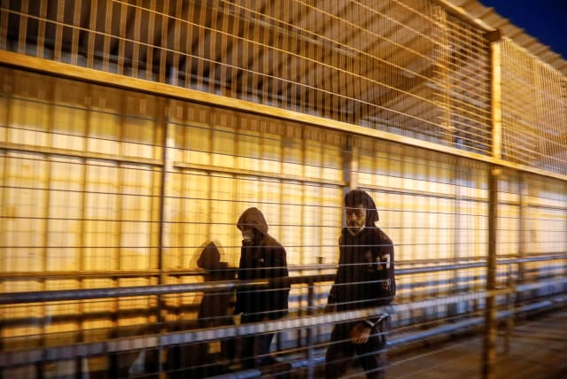  Palestinian laborers walk through an Israeli checkpoint on their way to their workplaces in Israel, Qalqilyam March 2, 2021 (photo credit: REUTERS/RANEEN SAWAFTA)