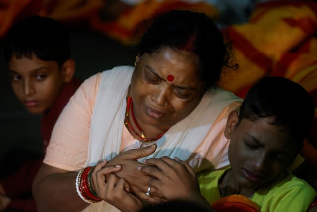  Chand Tara Sharma holds her grandchild as she mourns the loss of her son and his family, after flash floods were caused by a lake burst in Sikkim, India, October 8, 2023. (photo credit: REUTERS/FRANCIS MASCARENHAS)