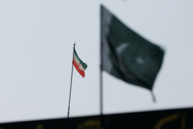 The flag of Iran is seen over its consulate building, with Pakistan's flag in the foreground, January 18, 2024. (photo credit: REUTERS/AKHTAR SOOMRO)