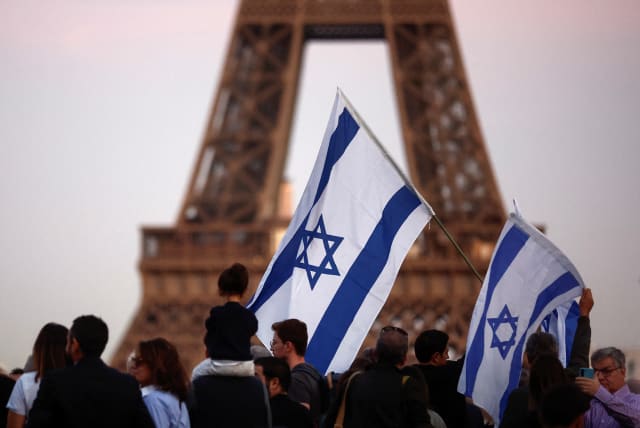  Israel supporters hold flags as they protest, following Hamas' biggest attack on Israel in years, in Paris, France, October 9, 2023 (photo credit: REUTERS/BENOIT TESSIER)