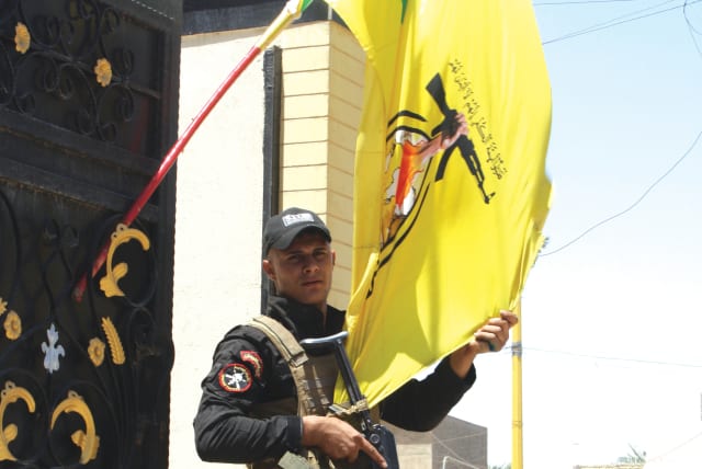 HEZBOLLAH FIGHTERS, with posters of Supreme Leader of Iran Ali Khamenei, are photographed by the author at the Badr group headquarters in Baghdad in 2015. (photo credit: JONATHAN SPYER)