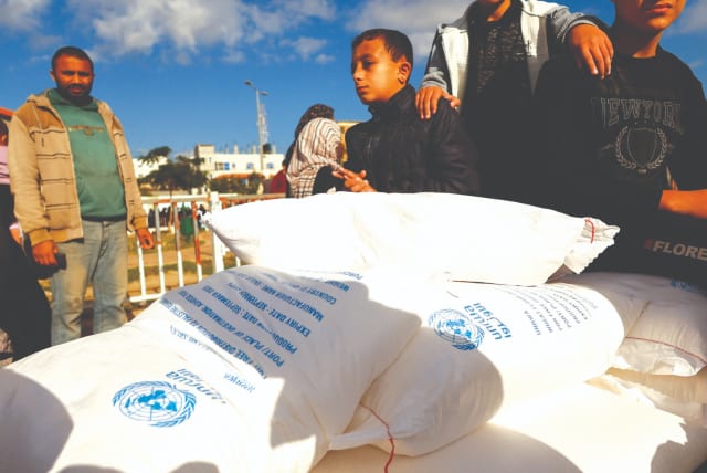  PALESTINIANS RECEIVE flour bags distributed by UNRWA in Rafah, in the southern Gaza Strip last November. (photo credit: IBRAHEEM ABU MUSTAFA/REUTERS)