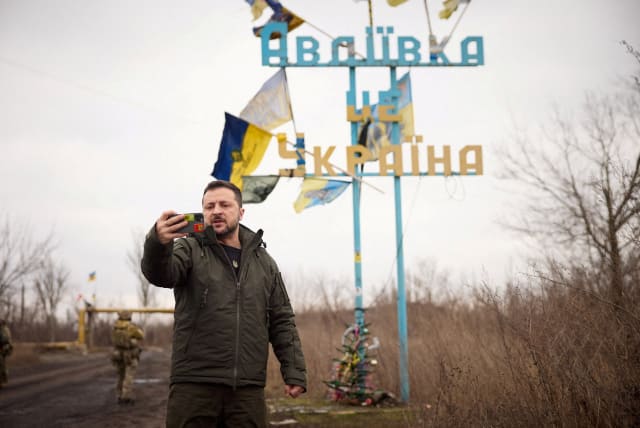  Ukraine's President Volodymyr Zelenskiy takes a video in front of a road sign with the words "Avdiivka this is Ukraine", amid Russia's attack on Ukraine, December 29, 2023. (photo credit: Ukrainian Presidential Press Service/Handout via REUTERS)