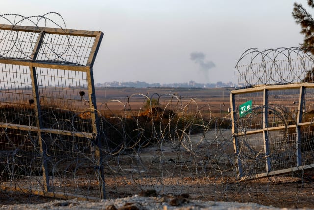  Smoke rises as seen from the broken fence in Kfar Aza where Hamas terrorists entered during the October 7tattack, in southern Israel, November 5, 2023 (photo credit: EVELYN HOCKSTEIN/REUTERS)