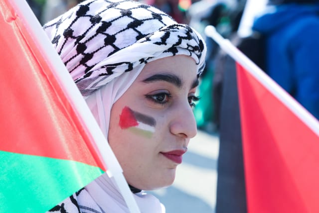  A woman with the colours of the Palestinian flag painted on her face attends a protest in support of Palestinians in Gaza, in Beirut, Lebanon February 11, 2024 (photo credit: MOHAMED AZAKIR/REUTERS)