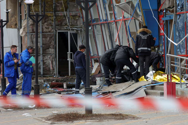  Specialists remove the body of a victim outside a heavily damaged shopping centre hit by a missile strike, what local authorities called a Ukrainian military attack, in the course of Russia-Ukraine conflict in Belgorod, Russia, February 15, 2024. (photo credit: REUTERS/STRINGER)