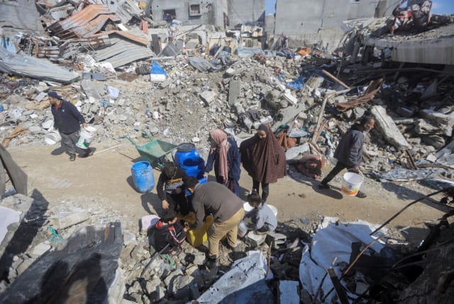  Palestinians gather to collect water from a house in Jabaliya refugee camp in the northern Gaza Strip. February 7, 2024 (photo credit: MAHMOUD ESSA/REUTERS)