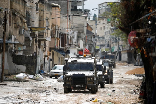  Military vehicles drive on a street during an Israeli raid at Tulkarm, in the West Bank, February 18, 2024. (photo credit: RANEEN SAWAFTA/REUTERS)