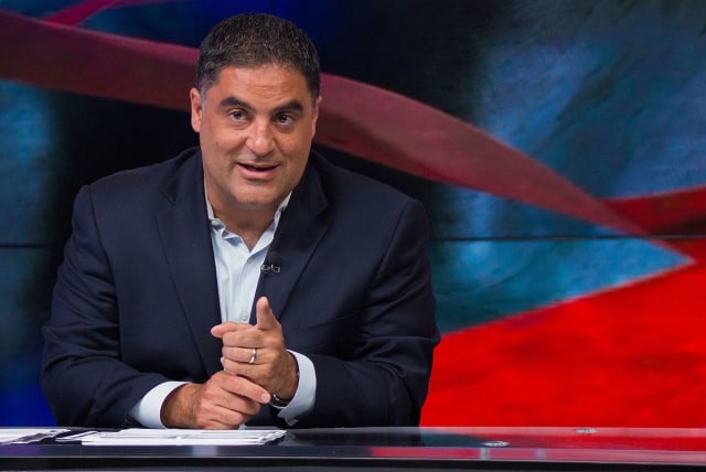 Cenk Uygur gesturing while hosting The Young Turks live streaming show on June 23, 2015. (photo credit: Wikimedia Commons)