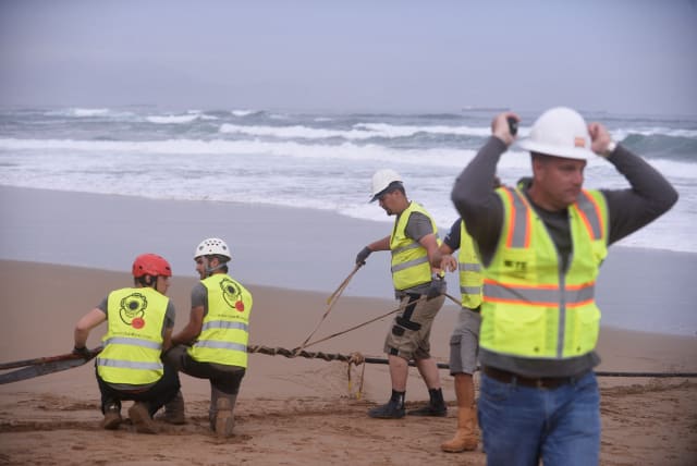  Workers operate on an (unrelated) lead line connected to fiber optic cable at Arrietara beach, near Bilbao, northern Spain, June 13, 2017, as Facebook Inc. and Microsoft Corp. join forces to build an underwater fiber optic cable across the Atlantic Ocean, linking Europe and the USA. (photo credit: REUTERS/VINCENT WEST/FILE PHOTO)