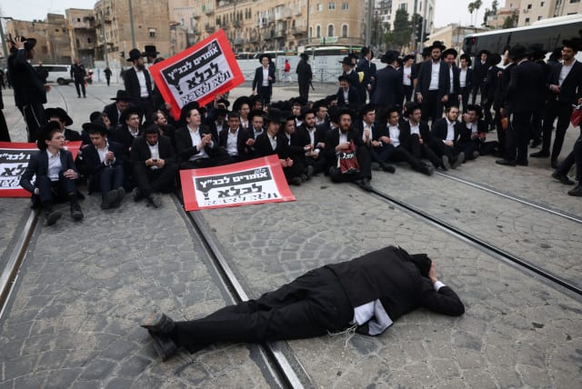 Ultra-Orthodox Jewish men protest against attempts to change government policy that grants ultra-Orthodox Jews exemptions from military conscription in Jerusalem February 26, 2024. (photo credit: RONEN ZVULUN/REUTERS)