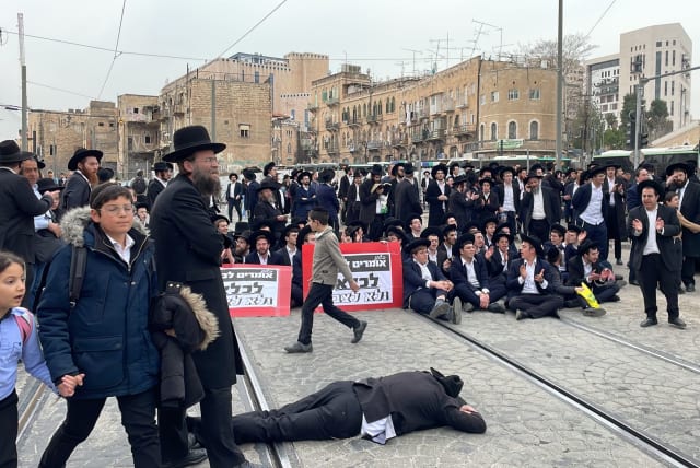 A group of ultra-Orthodox Jews blocked traffic and the light rail  in Jerusalem demonstrating against a Haredi draft into the IDF. February 26, 2024. (photo credit: SOL SUSSMAN)