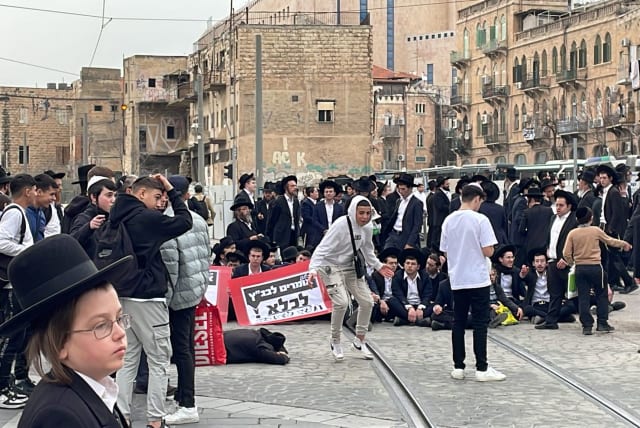  A group of ultra-Orthodox Jews blocked traffic and the light rail  in Jerusalem demonstrating against a Haredi draft into the IDF. February 26, 2024. (photo credit: SOL SUSSMAN)