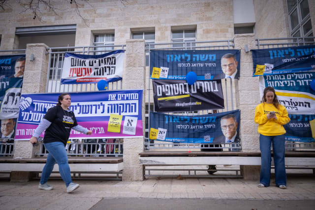  Campaign posters at a voting station on the morning of the Municipal Elections, in Jerusalem, on February 27, 2024 (photo credit: YONATAN SINDEL/FLASH90)