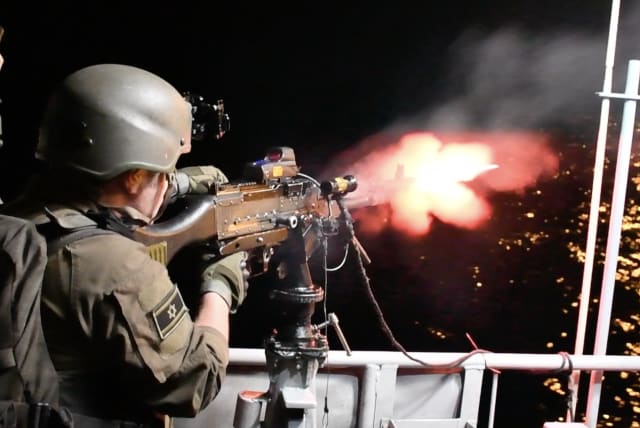  A NAVAL soldier fires his machine gun on the starboard side of a patrol boat during a drill off the coast.  (photo credit: SETH J. FRANTZMAN)