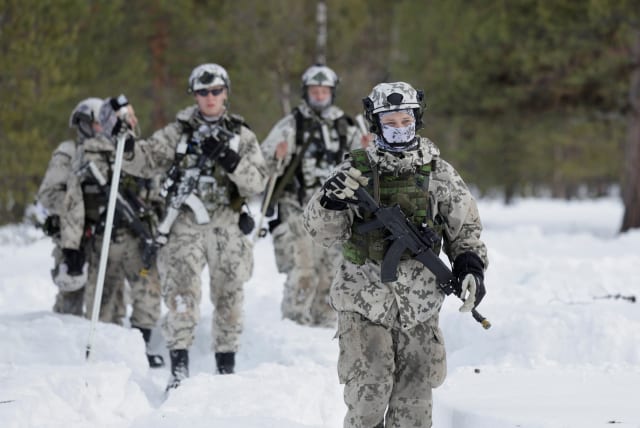  Army members walk in the snow as Finnish and Swedish troops participate in NATO's Nordic Response 24 exercise near Hetta, Finland, March 5, 2024.  (photo credit: Leonhard Foeger/Reuters)