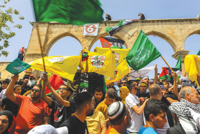  PALESTINIANS SHOUT slogans and wave flags, including of Hamas, depicting Israel as part of Palestine at al-Aqsa compound on the Temple Mount during Ramadan, last year. (photo credit: JAMAL AWAD/FLASH90)