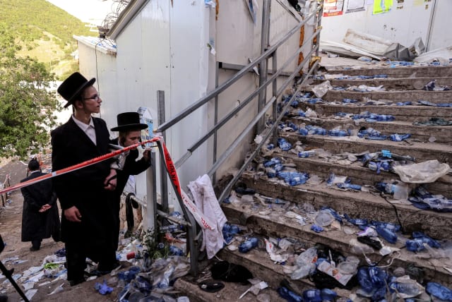  Ultra-Orthodox Jews look at stairs with waste on it in Mount Meron, northern Israel, following the Mount Meron tragedy. April 30, 2021.  (photo credit: REUTERS/Ronen Zvulun)
