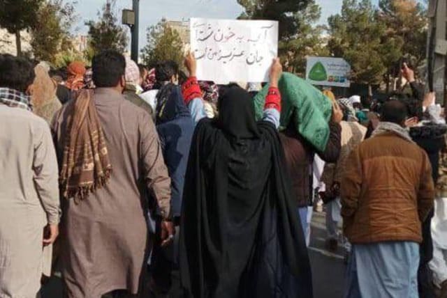  A woman in Zahedan holds a sign reading "What you’ve washed with blood is my dear soul." (photo credit: 1500tasvir)