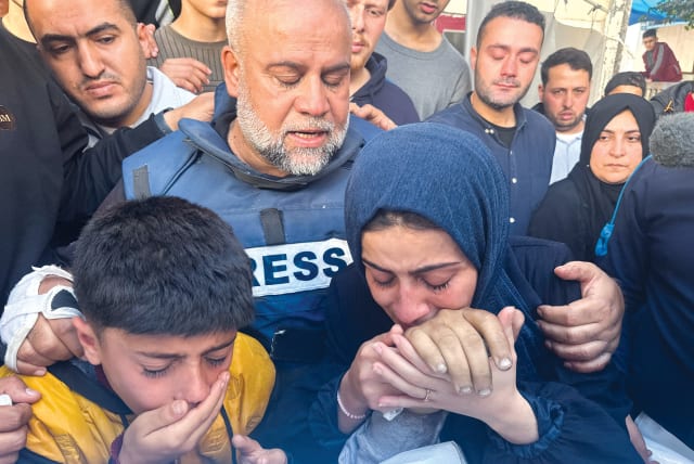  Al Jazeera bureau chief Wael Al-Dahdouh embraces his daughter and son as they attend the funeral on January 7 of his son, journalist Hamza Al-Dahdouh, who was killed in an Israeli strike in Rafah in the southern Gaza Strip.  (photo credit: MOHAMMED SALEM/REUTERS)