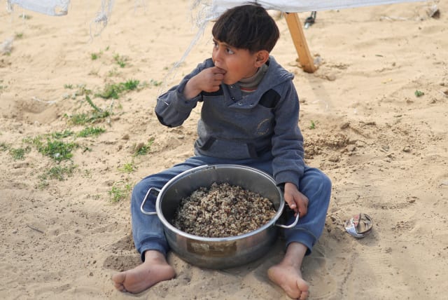  A DISPLACED Palestinian child eats at a tent camp amid food shortages in Rafah in the southern Gaza Strip. (photo credit: IBRAHEEM ABU MUSTAFA/REUTERS)