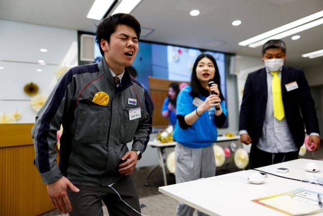  Masaya Shibasaki, 26, an employee of EXEO Group Inc., reacts as he tries the Osaka Heart Cool developed VR electrical device 'Perionoid' which releases electrical stimulation that feels like experiencing women's menstrual pain during a workshop Tokyo, Japan March 7, 2024. (photo credit: REUTERS/ISSEI KATO)