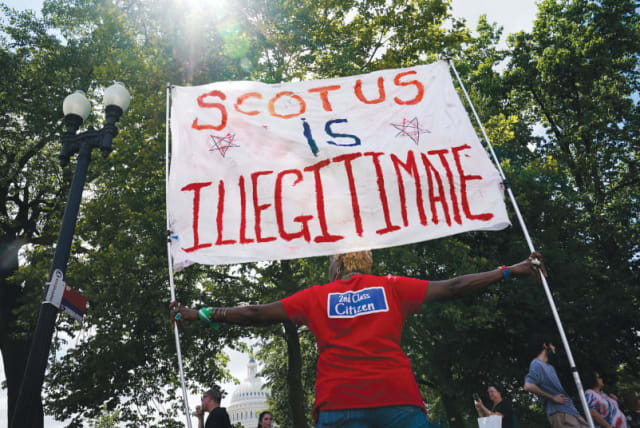 UNA activista por el derecho al aborto denuncia que el Tribunal Supremo de EE.UU. es "ilegítimo", en una protesta en Washington, en junio, en el primer aniversario de la sentencia judicial que anuló el caso Roe contra Wade. (photo credit: Elizabeth Frantz/Reuters)