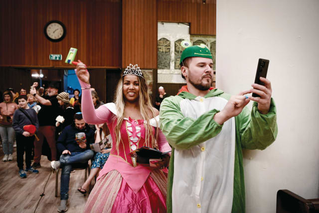  MEGILLAT ESTHER is read – with a becostumed queen in attendance– on Purim eve 2023, in Tel Aviv’s Great Synagogue. (photo credit: AVSHALOM SASSONI/FLASH90)